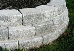 a circular stone garden bed in the grass