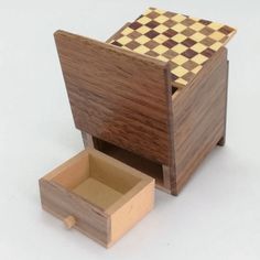 a small wooden box with a checkerboard pattern in it and an open drawer