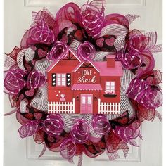 a pink and purple wreath with a house on it