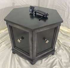 a black wooden box with two drawers on it's sides and one door open