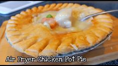 a close up of a pie on a wooden table with a spoon in the middle