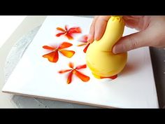 a person is decorating a plate with flowers on the side and an orange flower in the middle