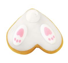 a close up of a cookie shaped like an eye patch with pink and white ears