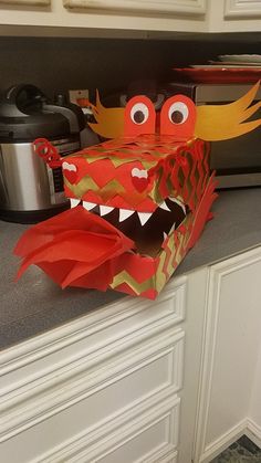 a paper bag that looks like a dragon with its mouth open and eyes wide open