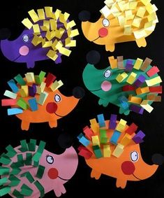 some paper crafts that are shaped like fish and hedgehogs on a black background