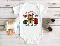 a baby's bodysuit with a teddy bear and presents on it