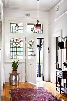 a large rug on the floor in front of a white door with stained glass windows