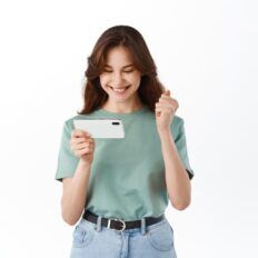 a woman holding up a white card and pointing it at the camera with both hands