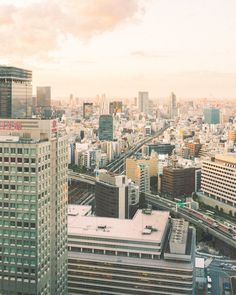 an aerial view of the city with skyscrapers and train tracks in the foreground