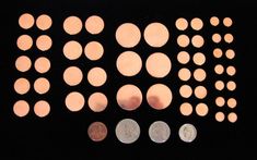 several different types of coins sitting on top of a black surface with light coming through them