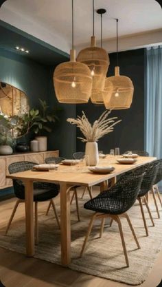 a dining room table with chairs and lights hanging from the ceiling