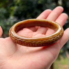 Jade Bangle Description --------------------------------- This jade bangle is 100% natural, untreated and undyed Type-A jadeite jade and is 100% handmade. Very lovely honey brown, purely created by our Mother Nature with delicate carvings of coins around the bangle, makes this bangle absolutely unique and beautiful. The sense of touch is cool. This piece has round shape with flat inner and round outer. Its flat inner would be fit your wrist perfectly. Simply but classic and well-matched for any outfit. This bangle is absolutely deserved to be addition to your collection or as a gift to your beloved one. **Note** The carving on the bangle is done to remove/ hide/ be less visible natural stone lines and imperfections. But there may still be some imperfections that is the main reason why the Burmese Jade, Sense Of Touch, Caramel Chocolate, Jade Bangle, Be Fit, Honey Brown, Jade Carving, Natural Jade, Burmese