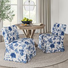 two blue and white chairs sitting in front of a round table with fruit on it