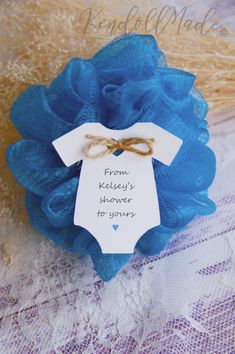 a blue flower with a tag attached to it on a lace doily next to some burlap