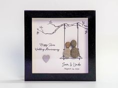 two rocks in a black frame with the words happy anniversary written on them