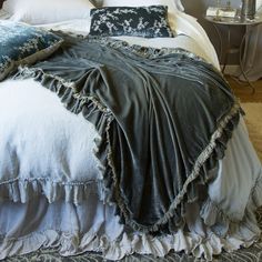 the bed is made up with blue and white linens on it, along with two nightstands