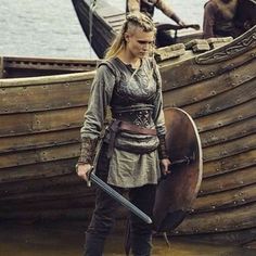 a woman is standing in front of a boat