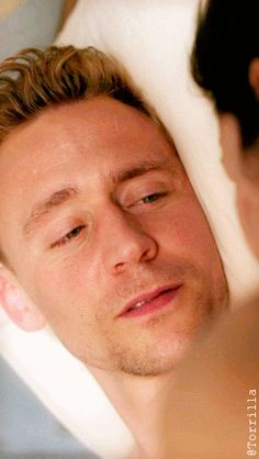 a man laying in bed with his eyes closed