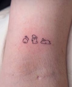 a small tattoo on the leg of a person with bunny ears and rabbits behind them