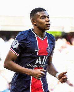 a young man is playing soccer in front of an audience at a sporting event,