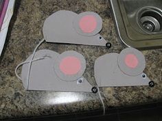 three pieces of paper cut out to look like mouses sitting on a counter top