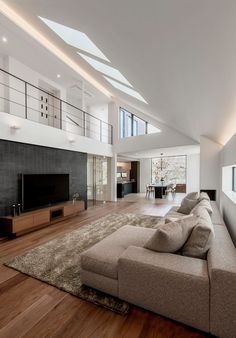 a living room filled with furniture and a flat screen tv on top of a wooden floor