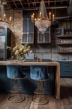 two blue stools sit in front of an island with lights hanging from the ceiling