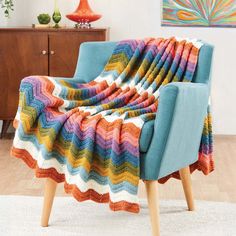 a blue chair with a multicolored blanket on it