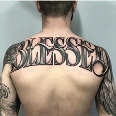 the back of a man's upper body with tattoos