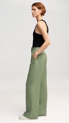 Made of Linen, this flattering silhouette features a high waist and a subtle wide leg. Functional details include an exterior credit card pocket, front side pockets and back welt pockets. Style with heels or sneakers; we recommend hemming according to your preferred shoe choice. Modern Wide Leg Pants With Welt Pockets, Sleek Spring Pants With Straight Hem, Sleek Straight Hem Pants For Spring, Classic Green Bottoms With Straight Hem, Modern Wide Leg Pants With Pressed Crease, Elegant Green Bottoms With Welt Pockets, Green Tailored Wide Leg Bottoms, Tailored Wide Leg Green Bottoms, Modern Wide Leg Bottoms With Pressed Crease