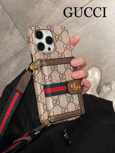 a person holding a gucci phone case in their left hand and the other hand is holding an iphone