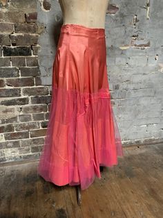 This is an absolutely gorgeous luscious piece. !950s silk petticoat/half slip. Very glamorous. The base is made from pink silk - probably habutae. Metal zipper. Two metal hooks and eyes at waist. The waist sits high. There is a 2" wide piece of elastic at the waist.  It is very slightly stretched. Still functioning but could perhaps be replaced. I don't personally think its serving any purpose. There is an outer layer of fine tulle starting quite low down over the silk.  It is kind of hitched up Pink Tulle Evening Skirt, Evening Pink Tulle Skirt, Pink Evening Skirt For Summer, Pink Skirt For Evening In Summer, Pink Skirt For Summer Evenings, Pink Tiered Evening Skirt, Pink Tiered Skirt For Evening, Fitted Pink Tulle Bottoms, Pink Tulle Full Skirt Bottoms