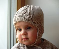 a small child wearing a knitted hat and scarf