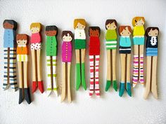 several wooden peg dolls lined up on a wall