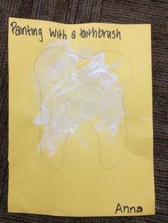 a yellow piece of paper with an image of a toothbrush on it that says painting with a toothbrush