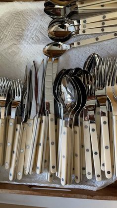 there are many forks and spoons on the table together with silverware in them