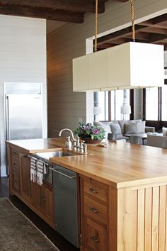 a kitchen with an island, sink and refrigerator in the middle of it's room