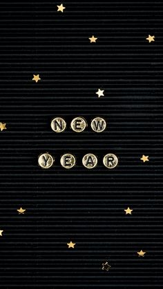 the words new year written in gold letters against a black background with golden stars on it