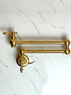 two brass towel bars on a white marble counter