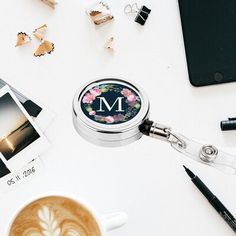 a cup of coffee sitting on top of a white table next to a cell phone