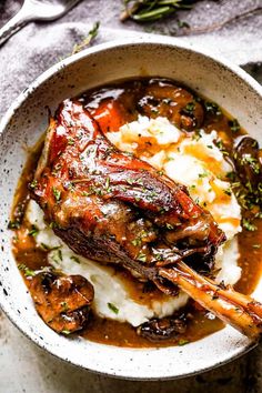 a white bowl filled with mashed potatoes and meat