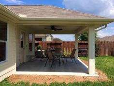 a covered patio with table and chairs in the middle of it on a sunny day