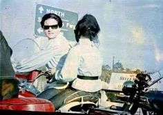 a man and woman riding on the back of a motorcycle