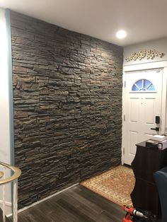 a room that has a stone wall in the corner and a rug on the floor