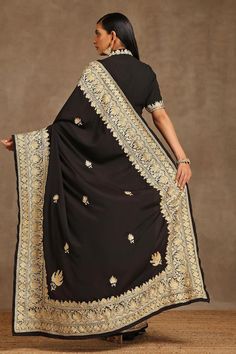 Black saree, accentuated with contrast kashmiri tilla embroidery. Paired with a front cut-out blouse with placement kashmiri tilla embroidery.
Components: 2
Pattern: Embroidery
Type Of Work: Kashmiri Tilla
Neckline: High Neck
Sleeve Type: Half Sleeves
Fabric: Crepe, Georgette, Lining: Cotton
Color: Black
Other Details: 

Blouse Length: 16 inches
Approx. product weight: 2 and 1/2 kg
Model height: 5ft 7inches, wearing size S
Inner lining
Occasion: Sangeet - Aza Fashions Black Silk Embroidered Saree Fabric, Black Semi-stitched Traditional Wear For Ceremonial, Designer Black Katan Silk Blouse Piece, Black Katan Silk Blouse For Designer Wear, Black Silk Embroidered Fabric For Diwali, Black Embroidered Pre-draped Saree For Navratri, Black Embroidered Fabric For Designer Wear, Black Silk Pre-draped Saree For Eid, Elegant Banarasi Silk Dupatta With Embroidered Border