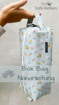 a hand holding a bag with flowers on it and the words box bag nananleiung