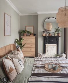 a bed room with a neatly made bed next to a dresser and mirror on the wall