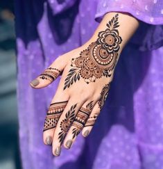 a woman's hand with henna tattoos on it