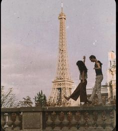 two people are walking near the eiffel tower