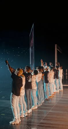 a group of people standing on top of a stage with their arms in the air